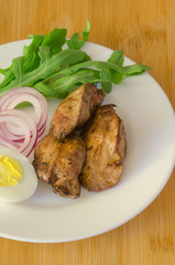 Roasted chicken liver with vegetable on wooden background