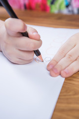 Small young girl drawing pictures with pencils