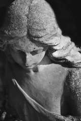 Vintage image of a sad angel on a cemetery against the black bac