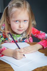 Small young girl drawing pictures with pencils