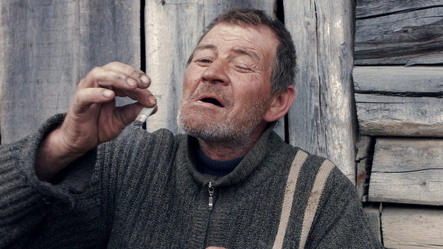 Poor old man smoking a homemade cigarette pathetic