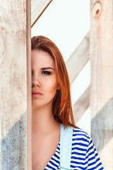 Emotional portrait of beautiful girl with wooden beams