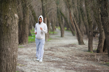 Fototapeta premium Cheerful young man jogging in nature