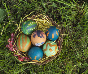 Basket full of colorfull Easter eggs at meadow