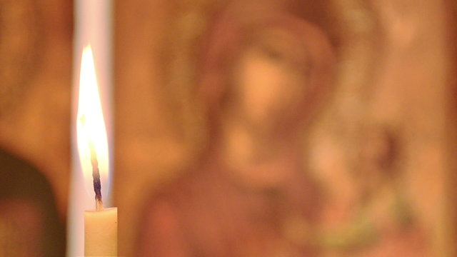 Candle in the background of the icon of the Virgin Mary