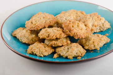 Freshly baked oatmeal cookies on a blue plate.
