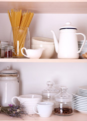 Obraz na płótnie Canvas Kitchen utensils and tableware on wooden shelves