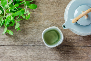 Teapot and cup of herbal tea with fresh mint
