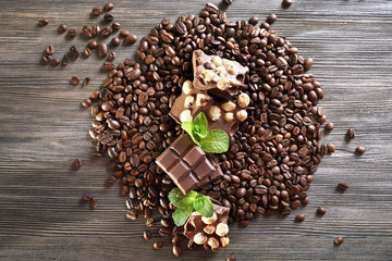 Chocolate with mint and coffee beans on wooden table, closeup