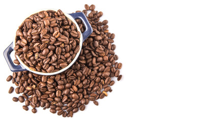 Roasted coffee beans in a blue ceramic pot over white background