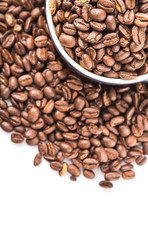 Roasted coffee beans in a blue ceramic pot over white background