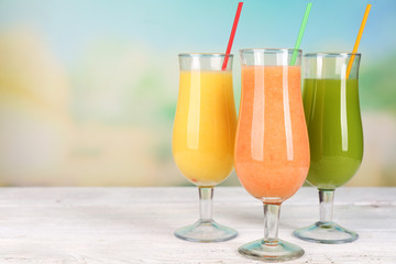 Fresh summer cocktails on wooden table on bright blurred background