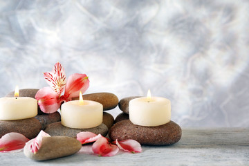 Still life with spa candles on light wallpaper background