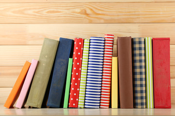 Books on shelf, close-up, on wooden background