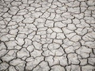 Dirty crack dry ground texture in salt pan.