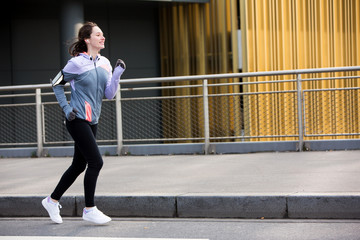 Fototapeta na wymiar Young attractive woman running downtown