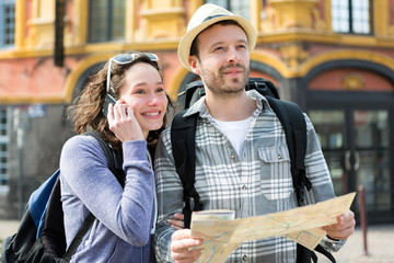 Couple of young attractive tourists watching map