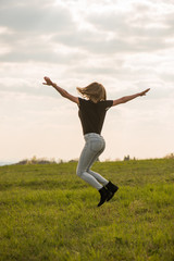 Happy Young Woman Jumping over blue sky