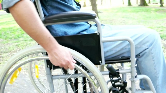 Detail of a man moving on a wheelchair