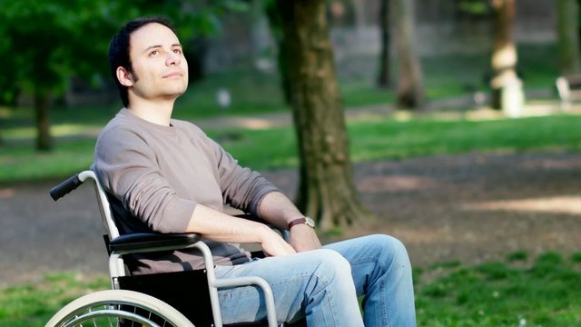 Man on a wheelchair relaxing in a park