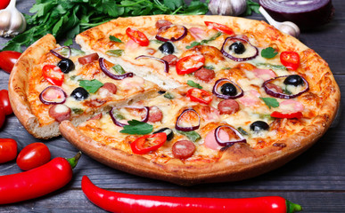 pizza with sausage, olives and chili pepper
