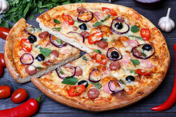 pizza with sausage, olives and chili pepper