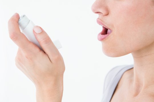 Asthmatic pretty brunette using inhaler