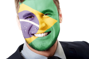 Happy man with Brasil flag on face.