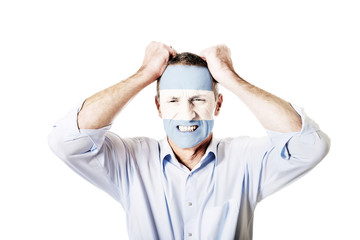 Mature man with Argentina flag on face.