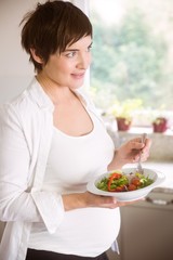 Obraz na płótnie Canvas Pregnant woman having bowl of salad