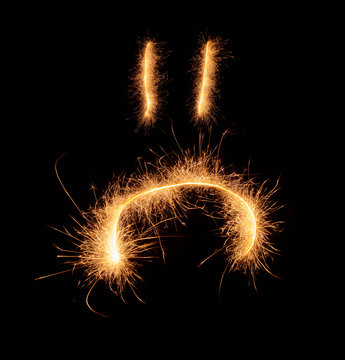 Upset weird sad smiley drawn with sparkles isolated on black