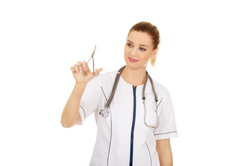 Doctor woman holding scissors.