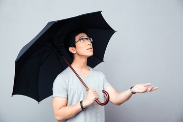 Asian man standing with umbrella