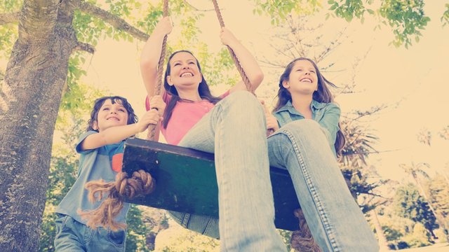 Kids Pushing Mother On Swing