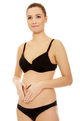 Fototapeta premium Fit young woman touching her belly.