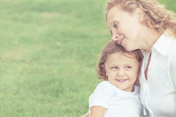 Mother and son playing on the grass at the day time.