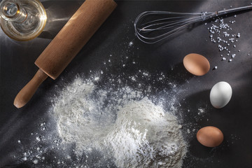 flour and ingredients on black table