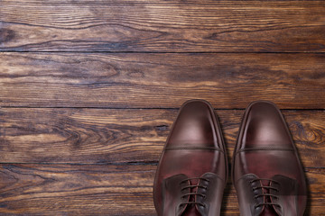 Fototapeta na wymiar Classic male brown leather shoes on wood