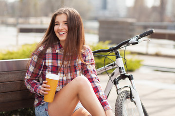 Young woman drinking coffee on a bicycle trip