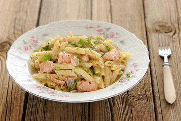 Creamy pasta with salmon and parsley in white plate