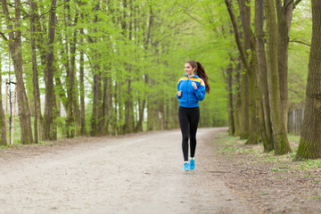 Fototapeta premium Young beautiful woman running on a trail