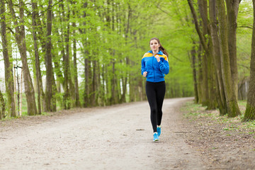 Young beautiful woman running on a trail