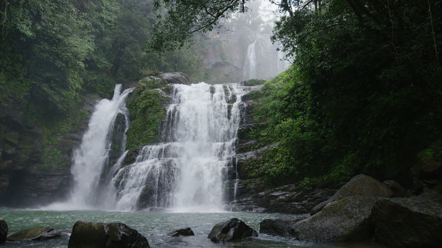 Wide panning slow motion view of waterfall in forest / Santa Juana, , Costa Rica