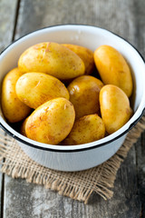raw baby potatoes on wooden surface
