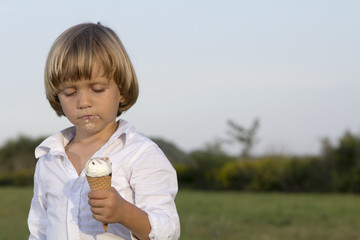 Young cute blond boy eating a tasty ice cream