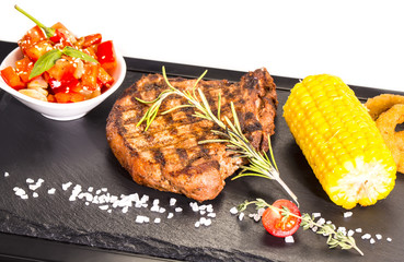 Grilled steak with sauce and greens