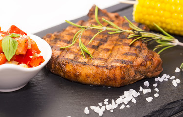 Grilled steak with sauce and greens