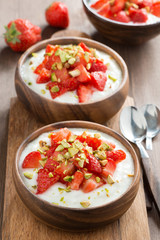 homemade yogurt with fresh strawberries and pistachios, top view