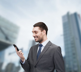 young smiling businessman with smartphone