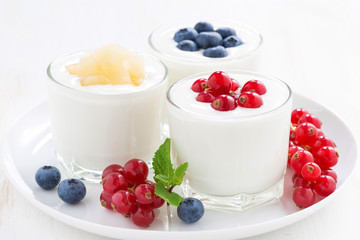 Natural yogurt with fresh berries in glass jars, close-up